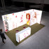 A bright and inviting Pixlip GO exhibition booth with a focus on fruity beverages. The illuminated panels feature vibrant images of cherries, drink cans, and smiling individuals enjoying beverages. The setup includes a central counter with matching graphics. A visitor approaches the booth.